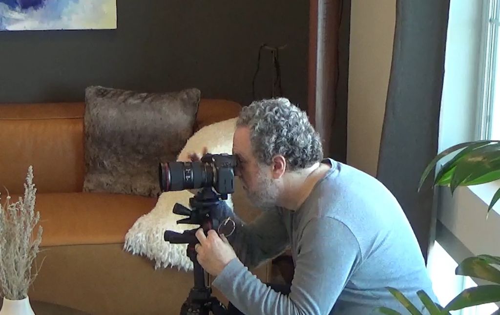 Real estate photographer adjusting camera settings for optimal shot